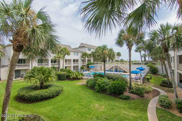 view of home's community featuring a swimming pool and a lawn