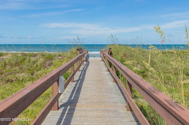 view of property's community featuring a water view and a beach view