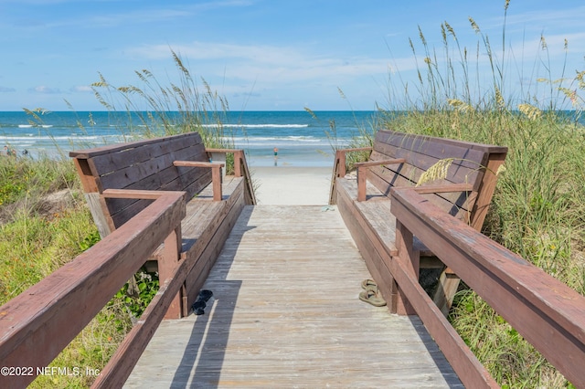 surrounding community featuring a water view and a beach view