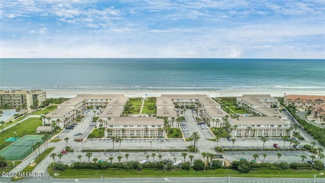 birds eye view of property with a water view and a beach view