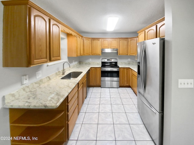 kitchen featuring sink, light stone counters, stainless steel appliances, and light tile patterned floors