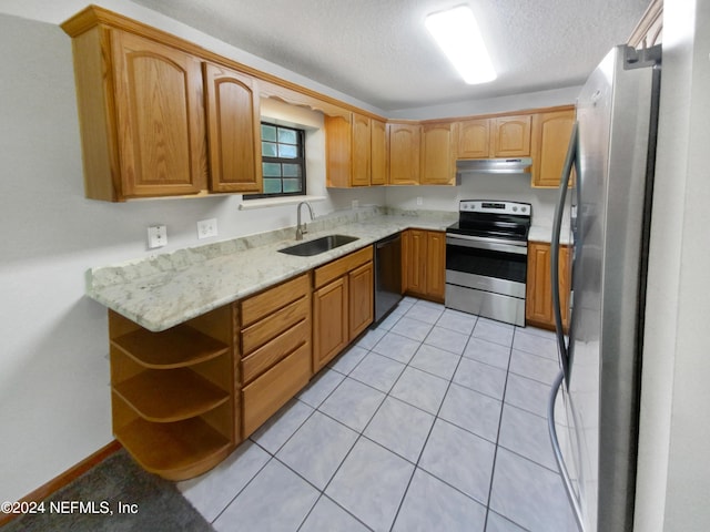 kitchen with appliances with stainless steel finishes, light stone counters, a textured ceiling, light tile patterned floors, and sink