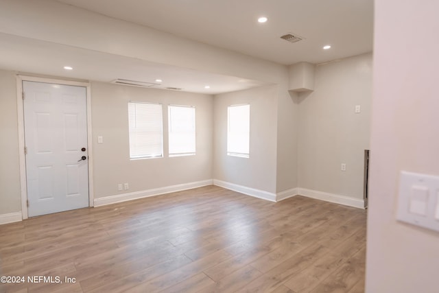 unfurnished room featuring light wood-style floors, visible vents, and baseboards