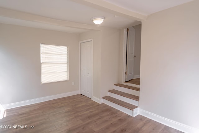 unfurnished room with baseboards and wood finished floors