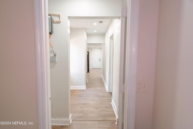 corridor featuring light wood-style floors, visible vents, baseboards, and recessed lighting