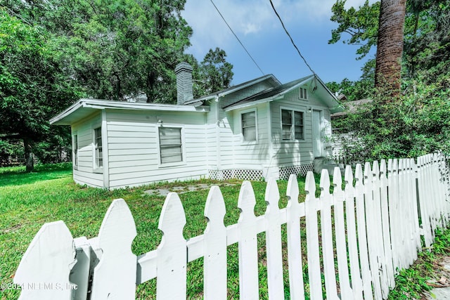 view of front of property with a fenced front yard, a chimney, and a front yard