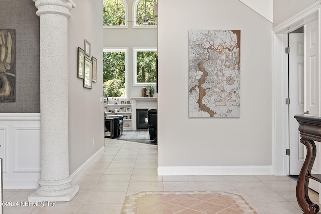 hallway with ornate columns and tile patterned floors