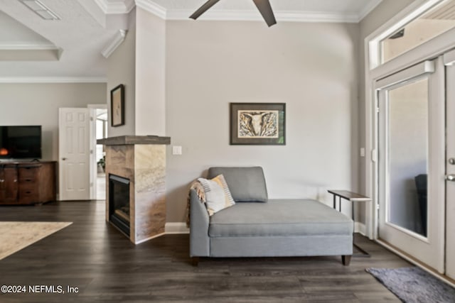 sitting room with a fireplace, visible vents, dark wood-style flooring, and crown molding