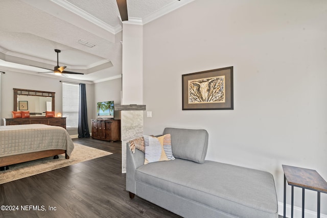 bedroom with a textured ceiling, dark wood-style flooring, visible vents, a tray ceiling, and crown molding