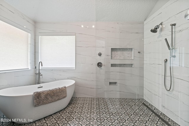 bathroom featuring lofted ceiling, a freestanding tub, a marble finish shower, and a textured ceiling