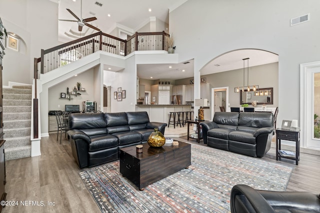 living room with stairway, visible vents, and light wood-style floors