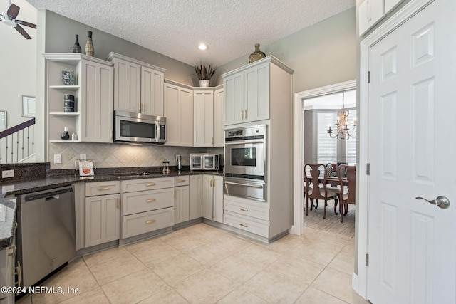 kitchen with light tile patterned flooring, ceiling fan with notable chandelier, appliances with stainless steel finishes, a warming drawer, and open shelves