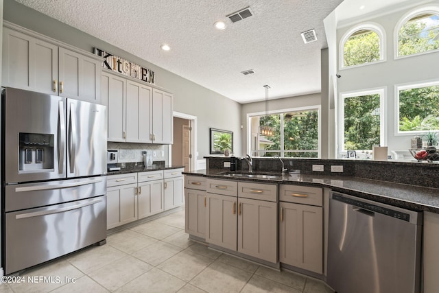 kitchen featuring stainless steel appliances, visible vents, a sink, and backsplash