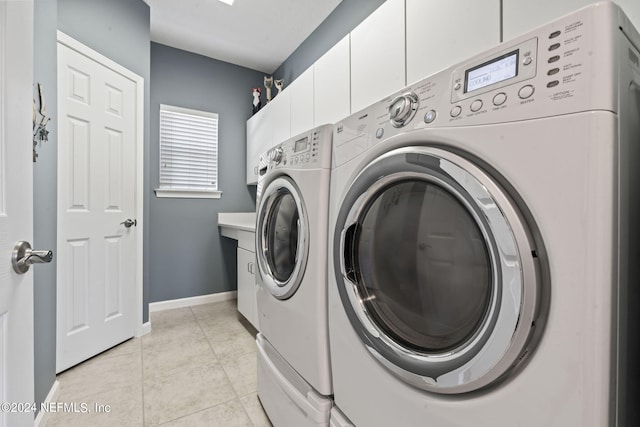 laundry area featuring cabinet space, baseboards, light tile patterned flooring, and independent washer and dryer