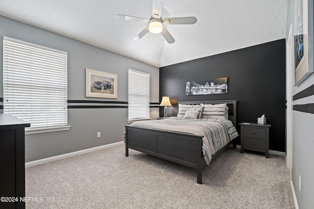 carpeted bedroom featuring ceiling fan, baseboards, vaulted ceiling, and a textured ceiling