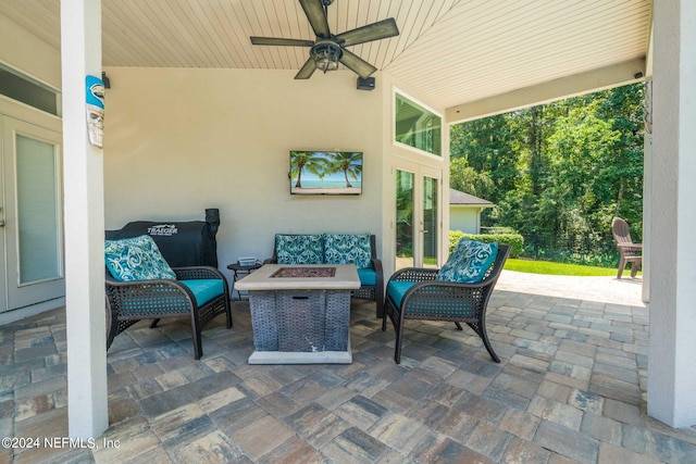 view of patio / terrace featuring a ceiling fan and an outdoor living space with a fire pit