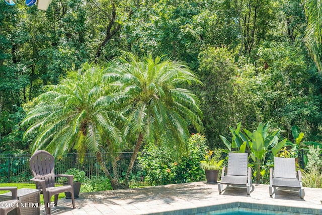 view of pool with a patio area and fence