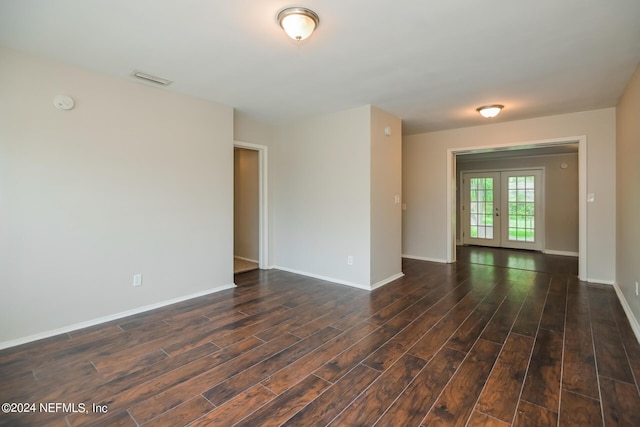 spare room featuring dark hardwood / wood-style flooring and french doors