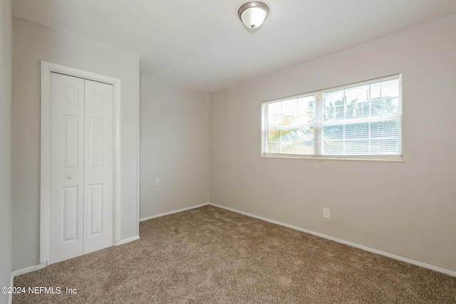 unfurnished bedroom with carpet floors and a closet