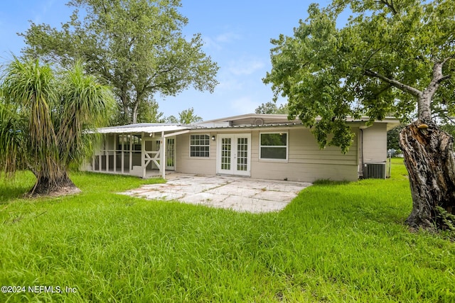 back of property with a lawn, central AC, a patio area, a sunroom, and french doors