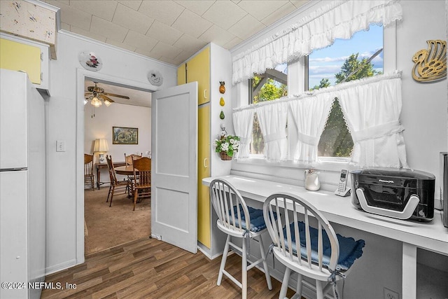 dining area with a ceiling fan, dark wood-style flooring, and built in study area