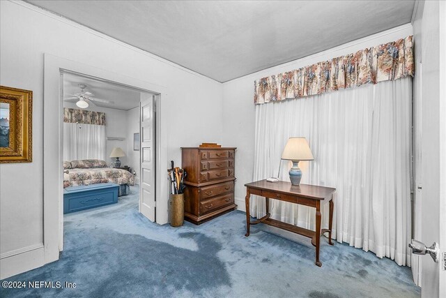 interior space featuring crown molding, carpet floors, and ceiling fan