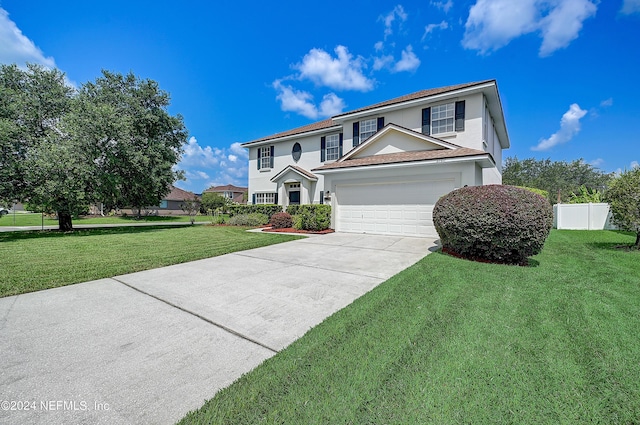 view of front facade featuring a front yard, driveway, fence, and stucco siding