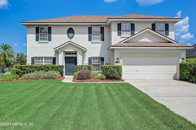 2701 N Portofino Rd, Saint Augustine, FL 32092 - view of front of house with an attached garage, a front lawn, concrete driveway, and stucco siding