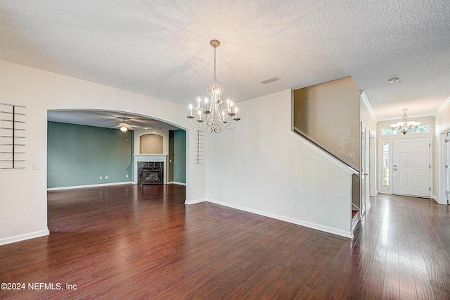 interior space with a textured ceiling, arched walkways, hardwood / wood-style flooring, a fireplace, and visible vents