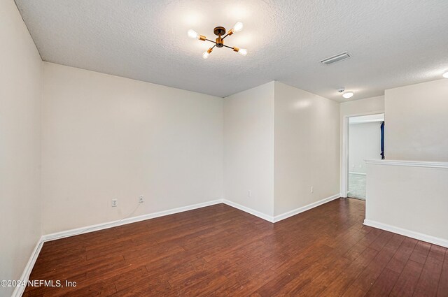 unfurnished room featuring a textured ceiling and hardwood / wood-style floors