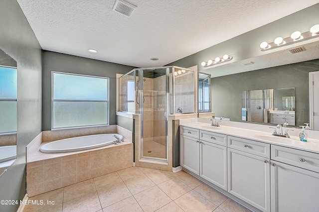 bathroom with shower with separate bathtub, dual bowl vanity, a textured ceiling, and tile patterned flooring