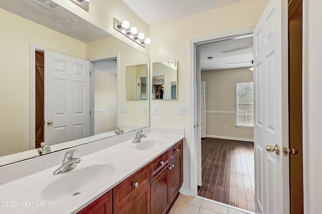 bathroom with dual bowl vanity, a textured ceiling, and hardwood / wood-style floors