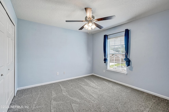 unfurnished bedroom featuring a closet, carpet flooring, a textured ceiling, and baseboards