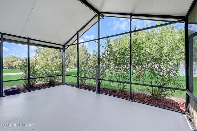 unfurnished sunroom featuring lofted ceiling and a healthy amount of sunlight