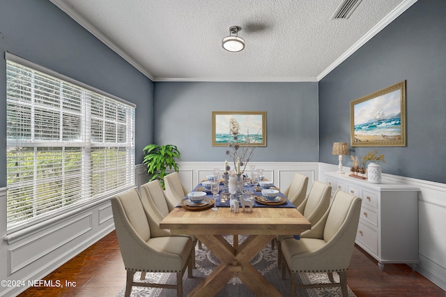 dining room with dark hardwood / wood-style flooring, ornamental molding, and a textured ceiling