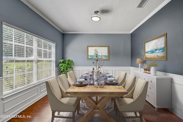 dining room featuring a wainscoted wall, a textured ceiling, visible vents, and dark wood-style flooring