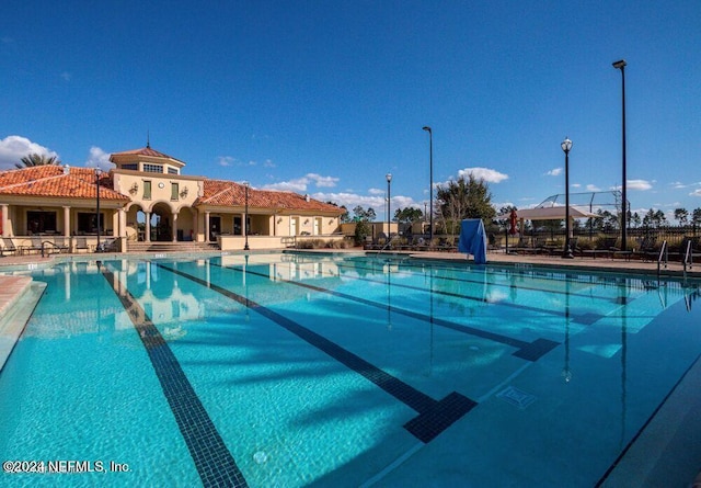 community pool featuring a patio area and fence