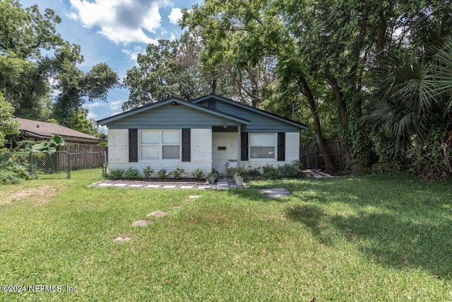 bungalow-style house with fence, a front lawn, and brick siding