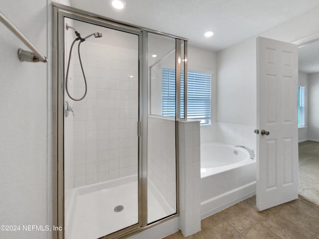 bathroom with tile patterned flooring, a wealth of natural light, and independent shower and bath