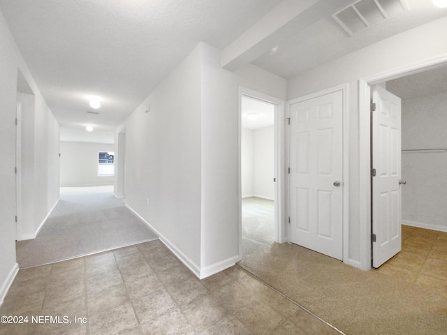 corridor featuring light colored carpet