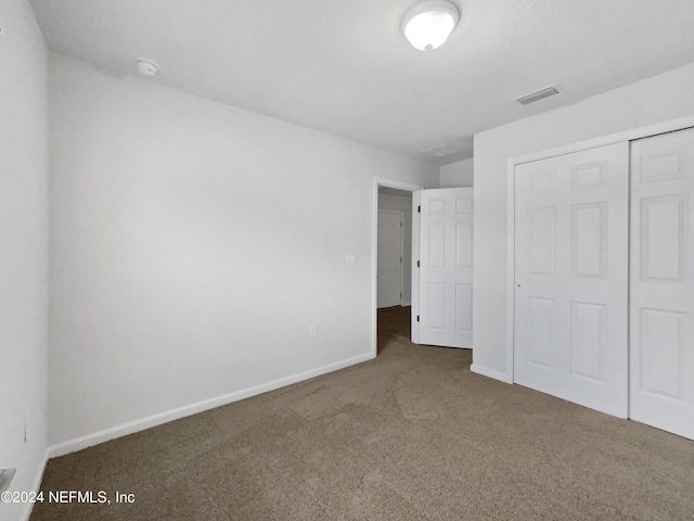 unfurnished bedroom featuring a closet and carpet