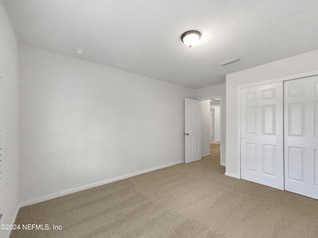 unfurnished bedroom with a closet and carpet flooring