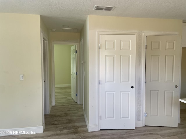 1058 W 17th St, Jacksonville, FL 32209 - hall featuring a textured ceiling, baseboards, visible vents, and wood finished floors
