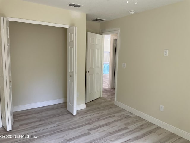 1058 W 17th St, Jacksonville, FL 32209 - unfurnished bedroom with light wood-style floors, baseboards, and visible vents