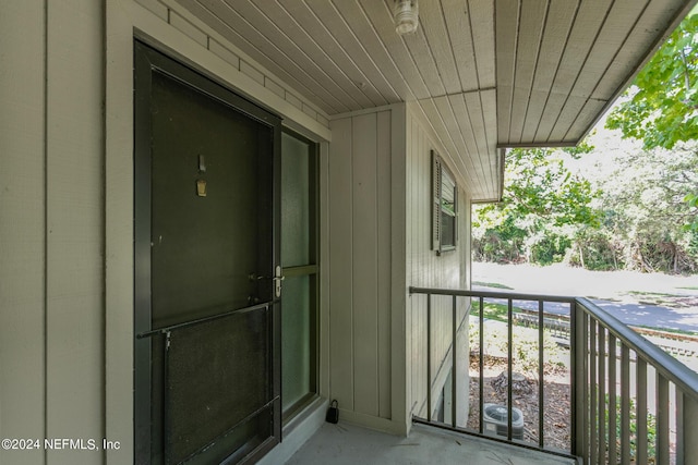 property entrance with board and batten siding and cooling unit