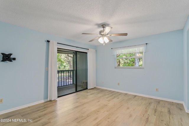 empty room featuring plenty of natural light, a ceiling fan, and wood finished floors