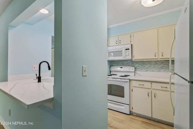 kitchen with backsplash, cream cabinets, white appliances, light wood-style floors, and crown molding