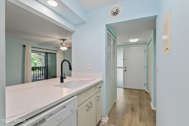 kitchen with visible vents, light wood-type flooring, light countertops, white dishwasher, and a sink