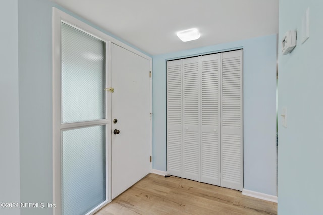 doorway to outside featuring light wood-style flooring and baseboards