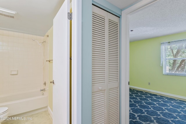 corridor with tile patterned floors, baseboards, and a textured ceiling